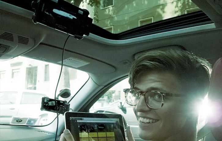 Marco in the car, holding the tablet through which he made the director